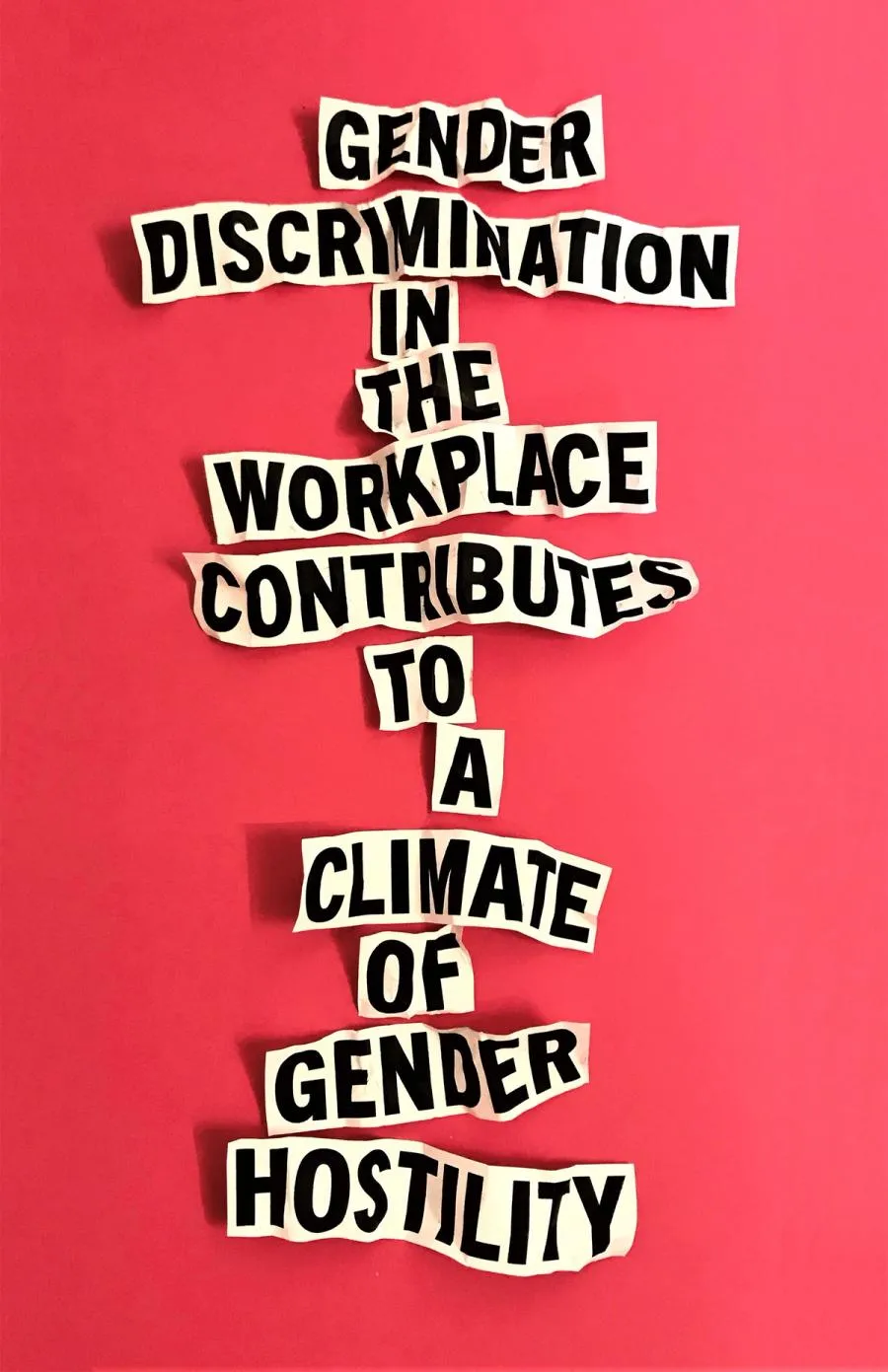 Poster with red background and text on scraps of paper: "Gender discrimination in the workplace contributes to a climate of gender hostility."